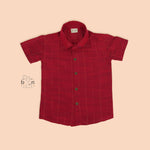 Maroon silk shirt with vertical golden lines, folded next to a traditional white veshti – boys' festive ethnic shirt by Boon Babies, Coimbatore.