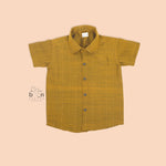 Mustard gold silk shirt with subtle golden stripes, folded beside a traditional white veshti – Boon Babies’ festive ethnicwear for boys in Coimbatore.