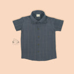 Boys silk shirt in steel blue with golden vertical stripes, paired with white dhoti – festivewear by Boon Babies, Coimbatore.