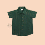 Bottle green silk shirt for boys with golden vertical threads, paired with white pattu dhoti – Boon Babies festive ethnic wear for toddlers.