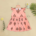 Peach cotton frock with bold leaf print and flutter sleeves. Made for girls aged 6 months to 5 years. Soft, breathable, and perfect for summer wear.