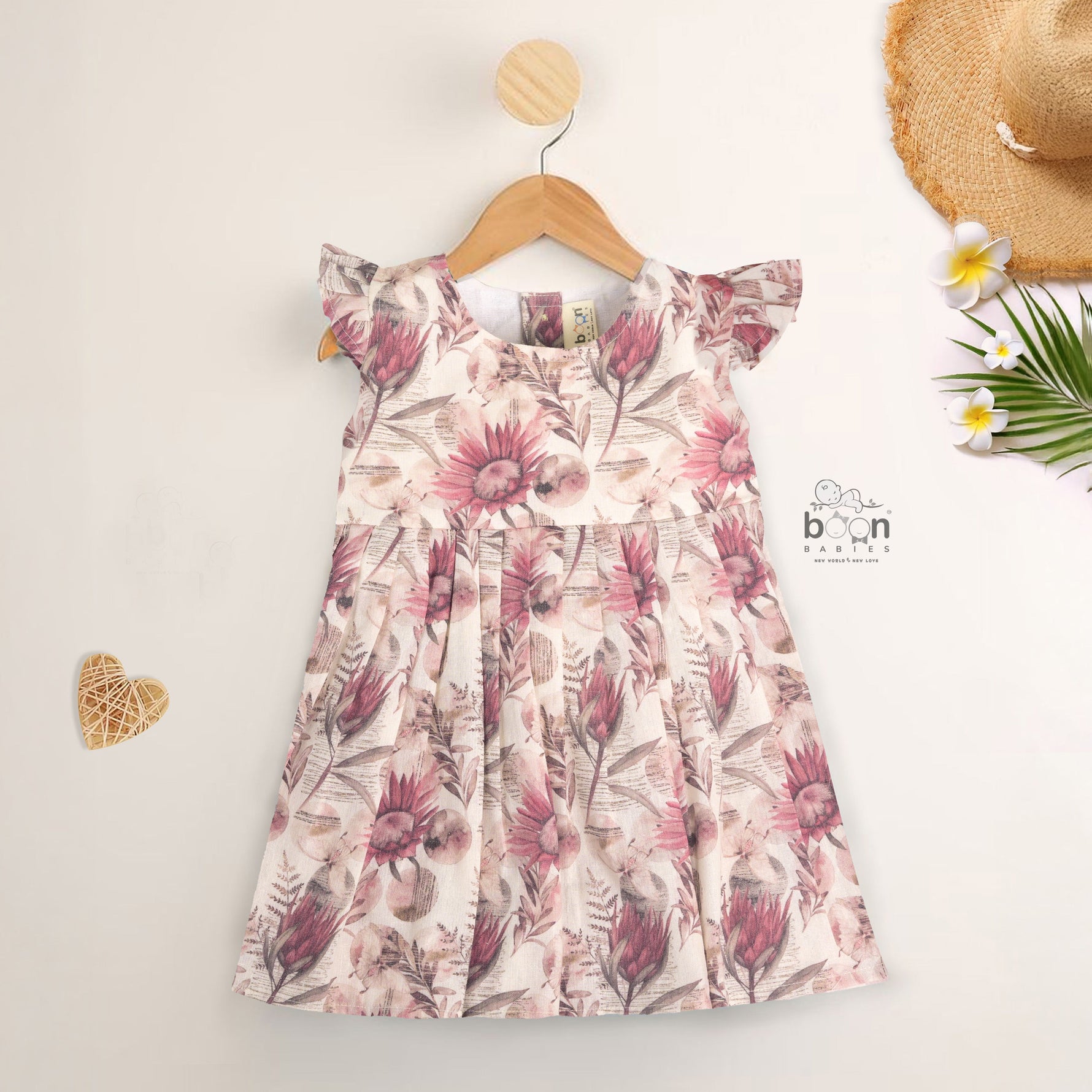 Pink floral cotton frock for girls with ruffle cap sleeves, designed for 6 months to 5 years – from Boon Babies clothing collection in Coimbatore.
