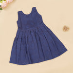 Navy blue sleeveless Hakoba frock for baby girls, featuring soft floral embroidery and pleated cotton design, placed flat on a beige backdrop with heart-shaped decor.