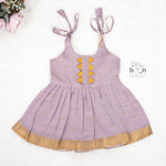 Lavender silk Onam knot frock with zari border & triangle yoke. Ages 0–12M. Perfect festive outfit for baby girls.