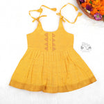 Bright yellow silk Onam knot frock with triangle yoke design & zari border. Perfect festive wear for baby girls (0–12M).