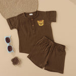 Olive green boys’ muslin shirt and shorts set with tiger face embroidery, wooden buttons, and elastic shorts – soft summer outfit by Boon Babies, Coimbatore.