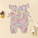 Baby girl romper in soft crinkled muslin with multicolor floral print, flutter sleeves, and side bows – ideal for babies aged 0–12 months by Boon Babies, Coimbatore.