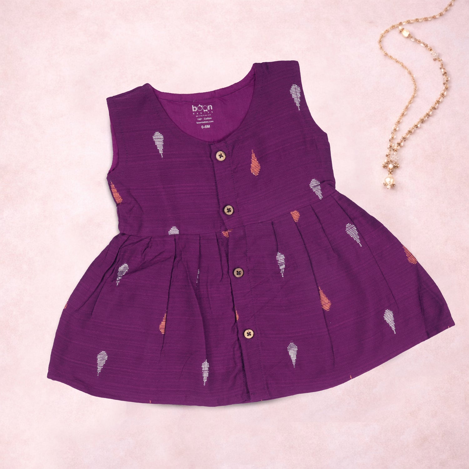 Baby girl wearing a purple ethnic sleeveless frock by Boon Babies, featuring traditional design and soft fabric.