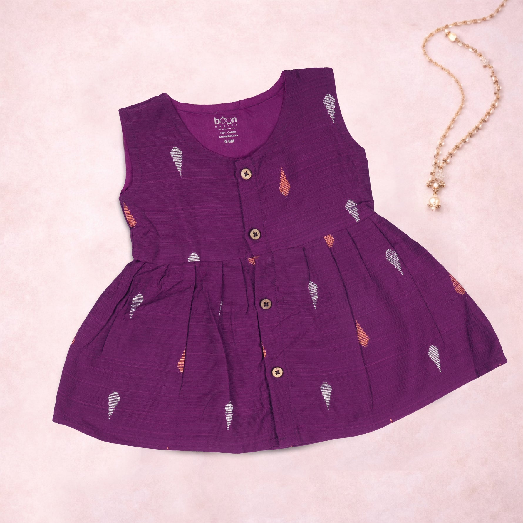 Baby girl wearing a purple ethnic sleeveless frock by Boon Babies, featuring traditional design and soft fabric.