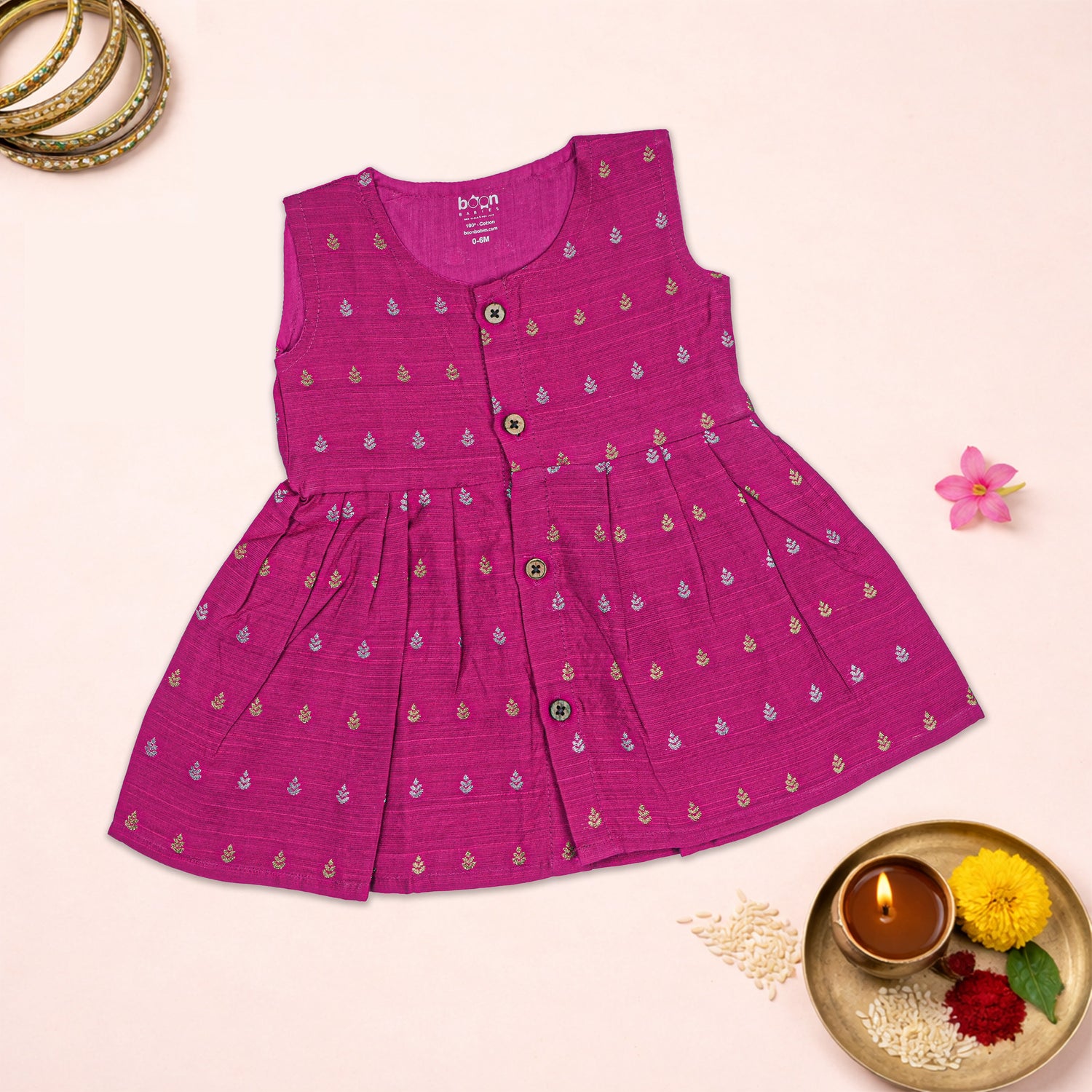 Baby girl wearing a magenta pink ethnic sleeveless frock by Boon Babies, with traditional embroidery and colorful design.