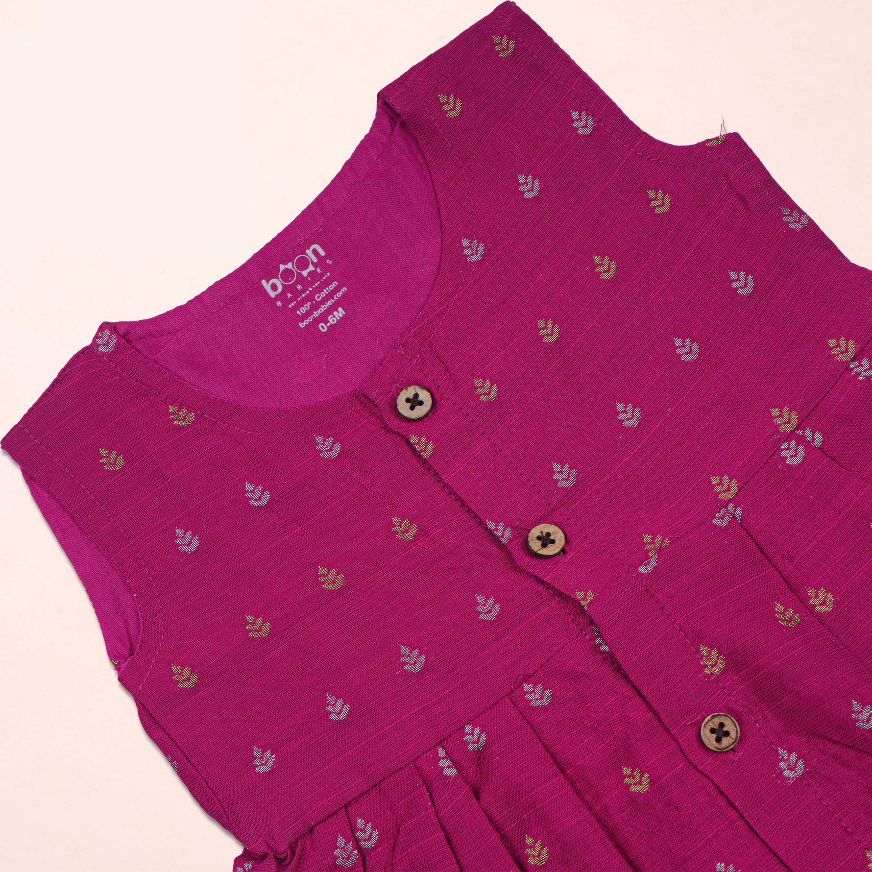 Baby girl wearing a magenta pink ethnic sleeveless frock by Boon Babies, showcasing traditional style and vibrant fabric details.