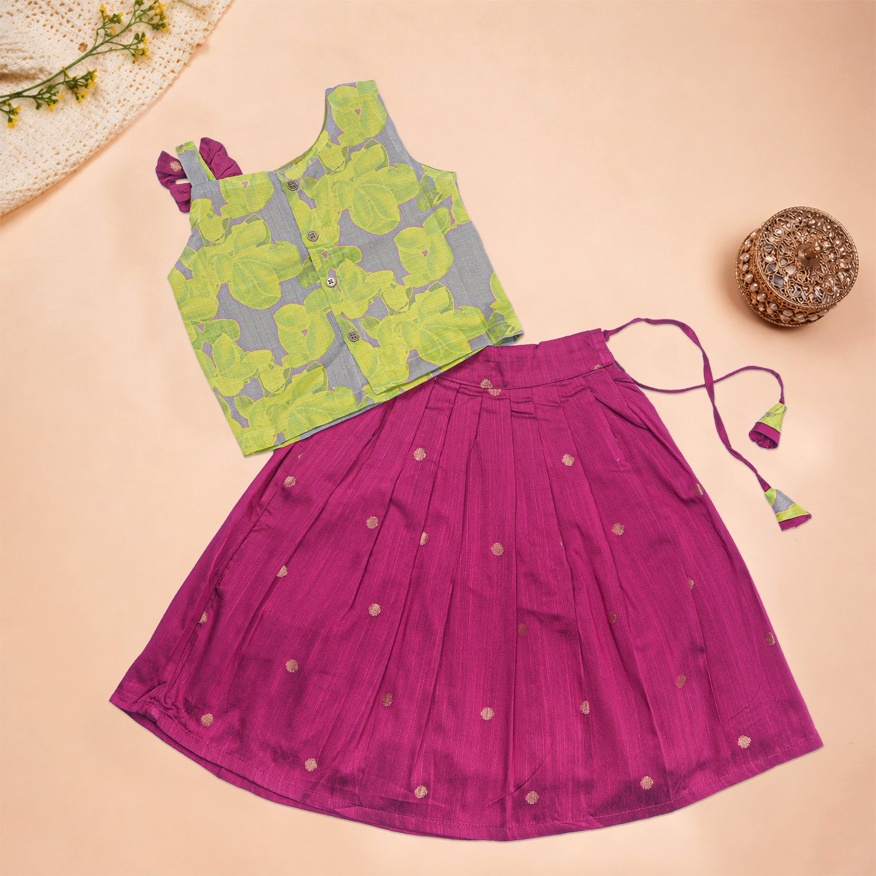 Girls leaf printed ethnic top and magenta pleated skirt set by Boon Babies, featuring a leafy print top and vibrant pleated skirt.