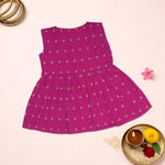 Baby girl in a magenta pink ethnic sleeveless frock by Boon Babies, showcasing intricate embroidery and vibrant fabric.
