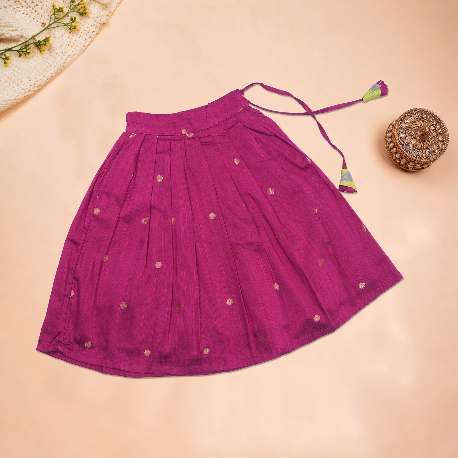Girls leaf printed ethnic top and magenta pleated skirt set by Boon Babies, featuring a leaf pattern on the top and a vibrant pleated skirt.