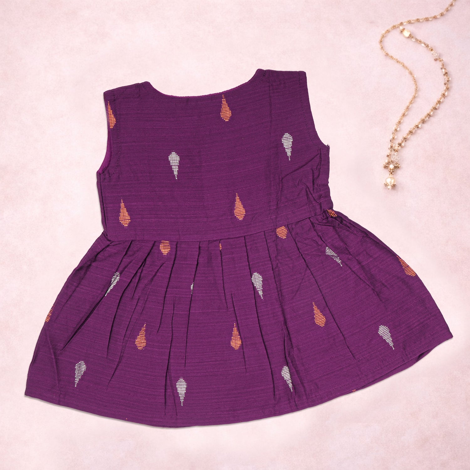 Baby girl wearing a purple ethnic sleeveless frock by Boon Babies, featuring traditional design and comfortable fabric.