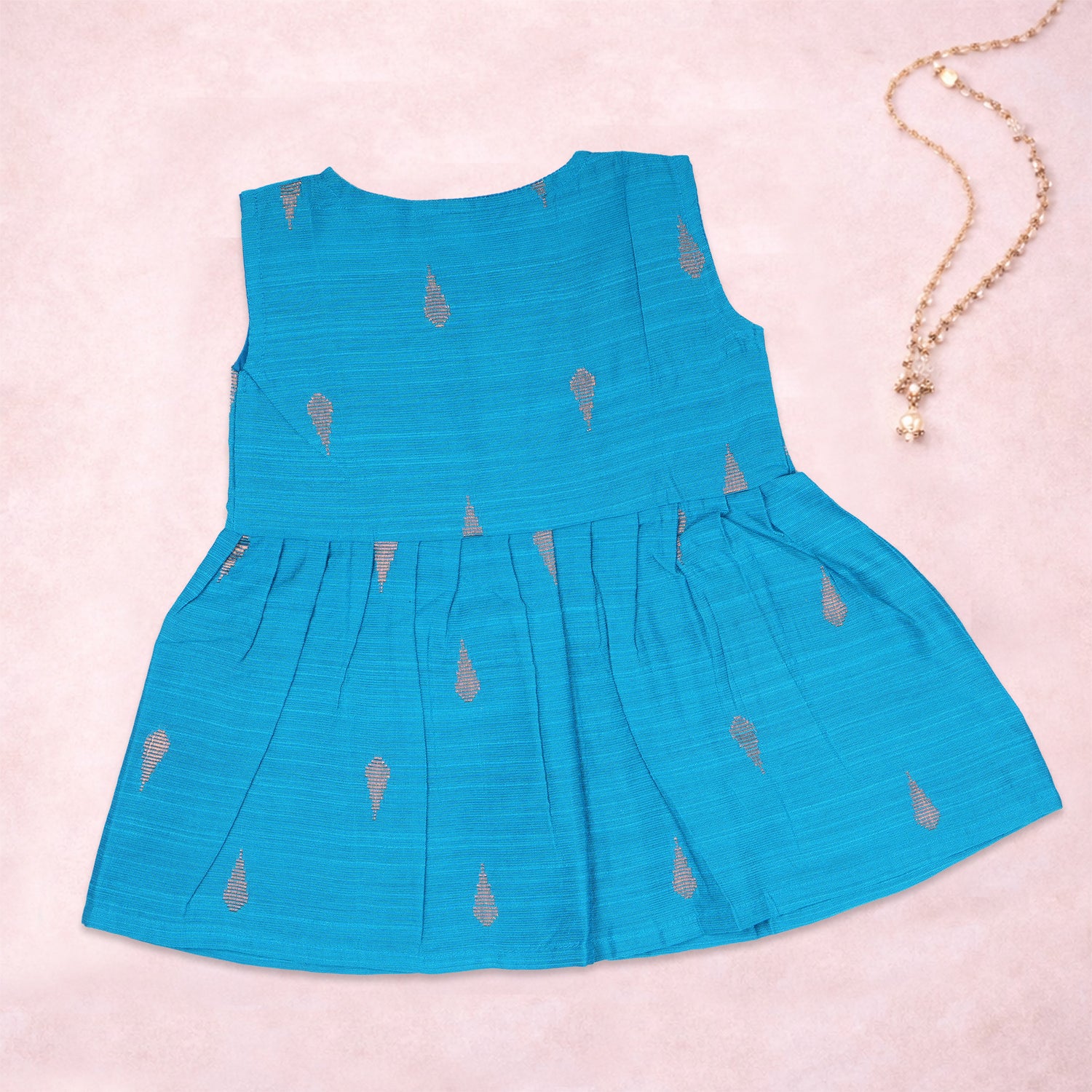 Baby girl wearing a blue ethnic sleeveless frock by Boon Babies, showcasing traditional style and comfortable fit.