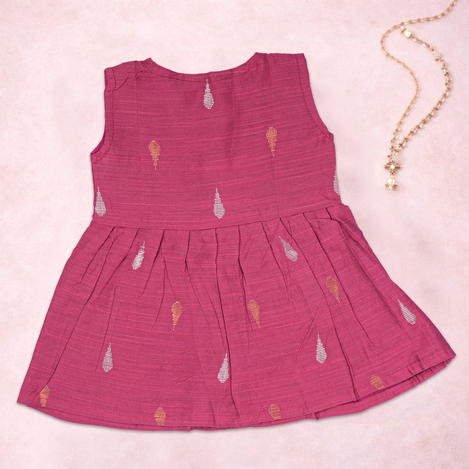 Baby girl wearing a pink ethnic sleeveless frock by Boon Babies, featuring intricate traditional embroidery and comfortable fabric.