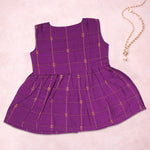 Baby girl wearing a purple ethnic sleeveless frock by Boon Babies, featuring traditional embroidery and comfortable fit.