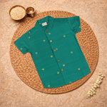 Boys bottle green silk butta shirt and dhoti set by Booon Babies, traditional ethnic wear for boys, with intricate design details.
