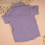 Boy wearing a lightweight solid polycotton popcorn shirt with a regular collar for ages 6 months to 5 years, casual and comfortable.