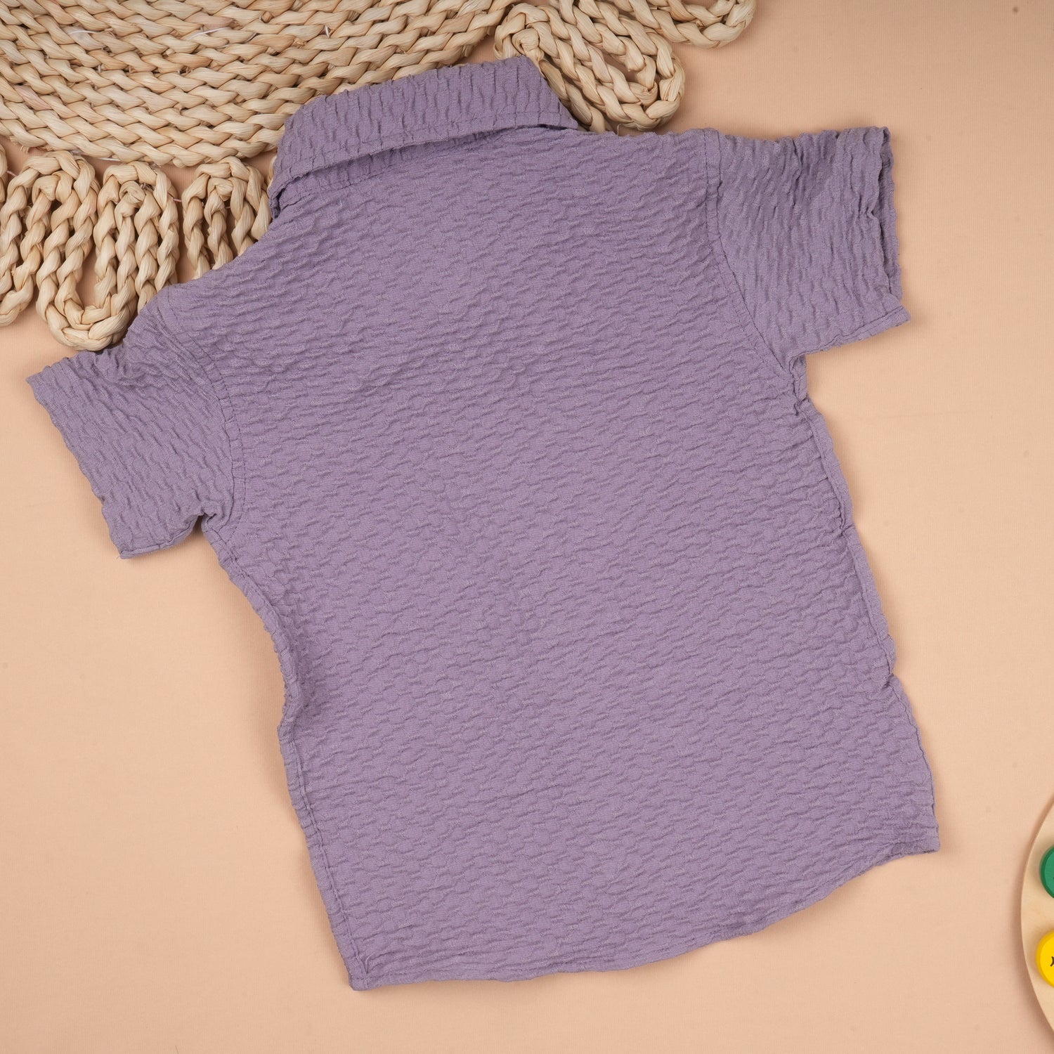 Boy wearing a lightweight solid polycotton popcorn shirt with a regular collar for ages 6 months to 5 years, casual and comfortable.