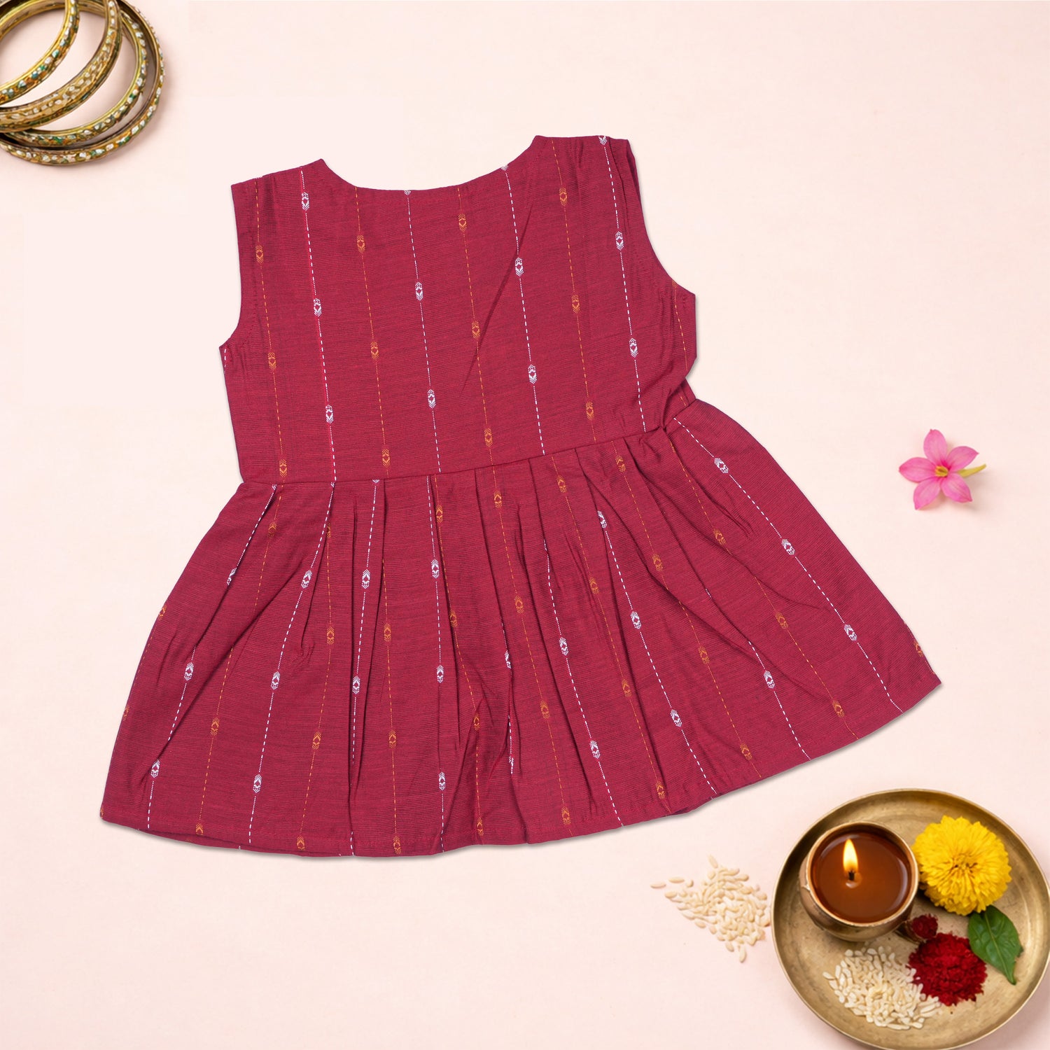 Baby girl wearing a cherry red ethnic sleeveless frock by Boon Babies, featuring traditional design and comfortable fit.