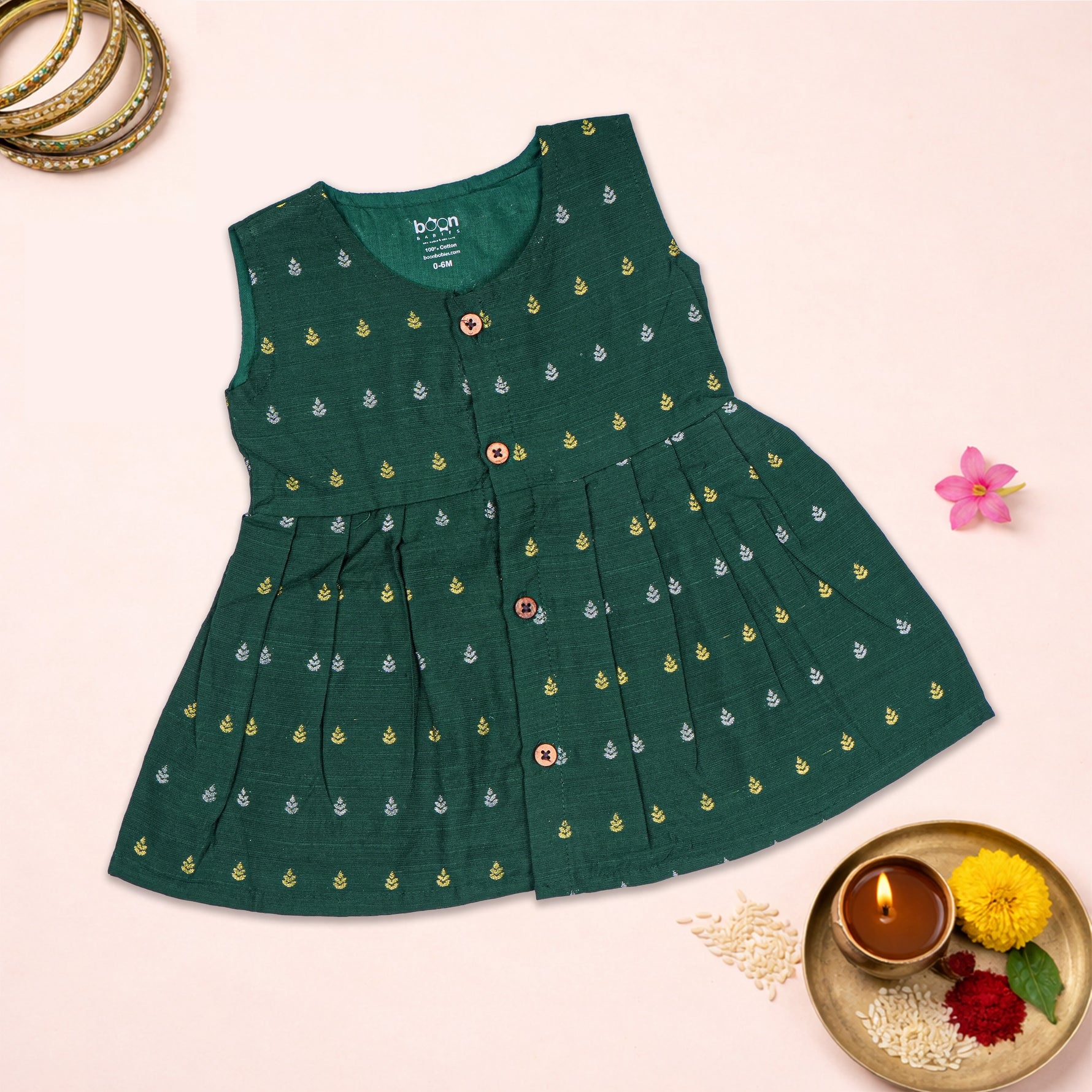Baby girl wearing a green ethnic sleeveless frock by Boon Babies, showcasing traditional design and vibrant fabric.