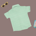 Boys mint green cotton shirt and shorts set with printed design and straight collar, by Boon Babies, laid flat on a white background.