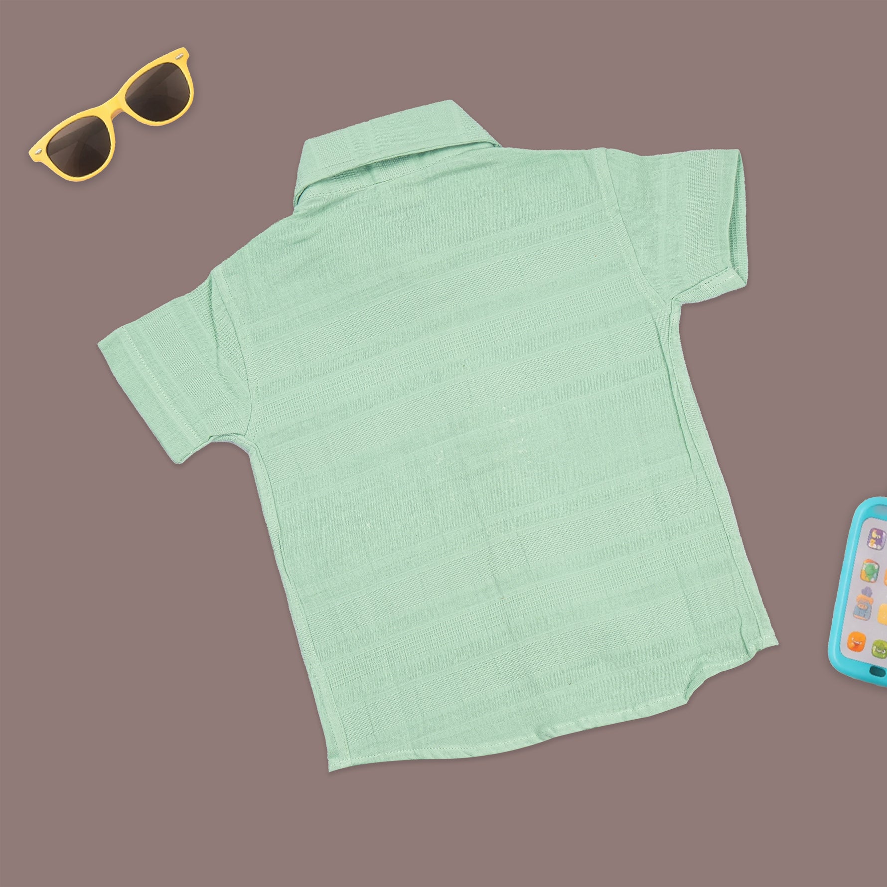 Boys mint green cotton shirt and shorts set with printed design and straight collar, by Boon Babies, laid flat on a white background.