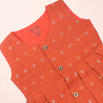 Baby girl wearing an orange ethnic sleeveless frock by Boon Babies, featuring traditional design and lightweight fabric.