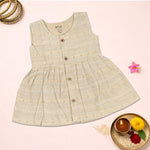Baby girl wearing a premium ivory ethnic sleeveless frock by Boon Babies, showcasing the detailed embroidery and elegant design.