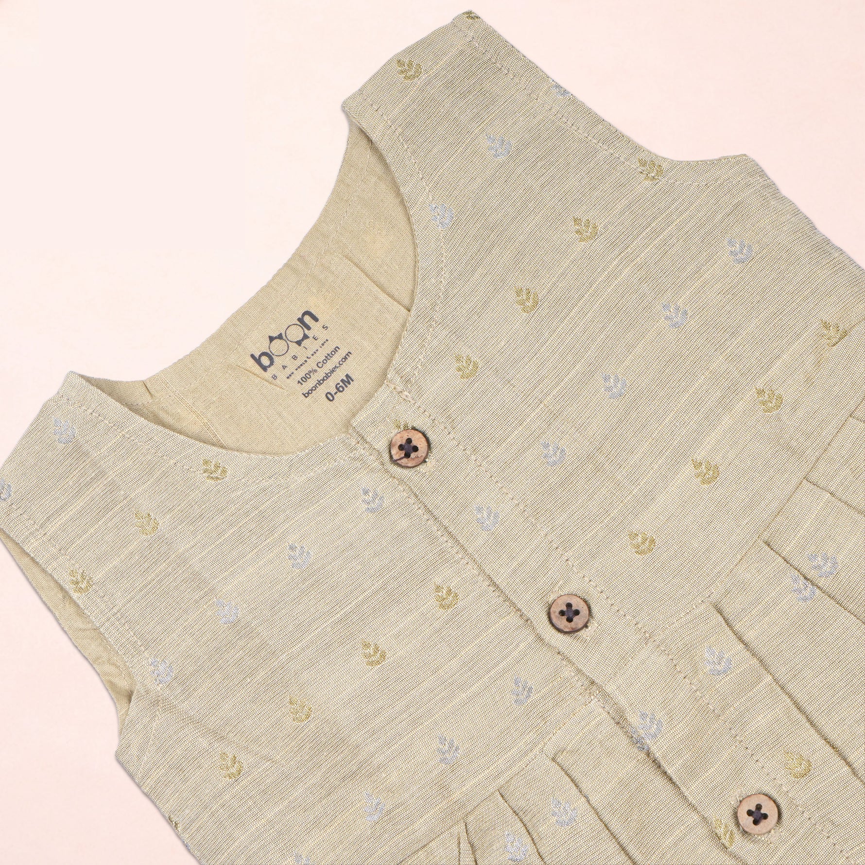 Baby girl wearing a premium ivory ethnic sleeveless frock by Boon Babies, featuring traditional design and soft fabric.