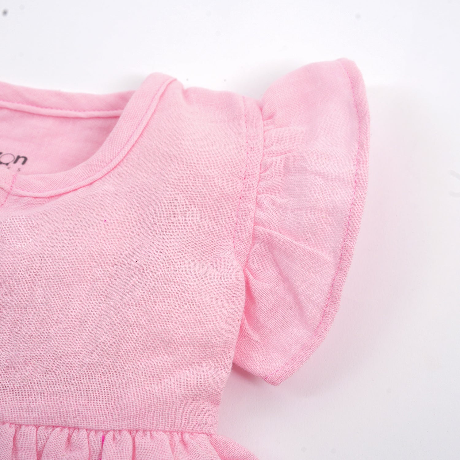 Soft pink crinkled muslin baby girl frill frock with ruffle details, perfect for comfortable and stylish little outfits.