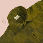 Olive green silk shirt with golden check pattern, folded neatly – traditional ethnic wear for baby boys from Boon Babies, Coimbatore.