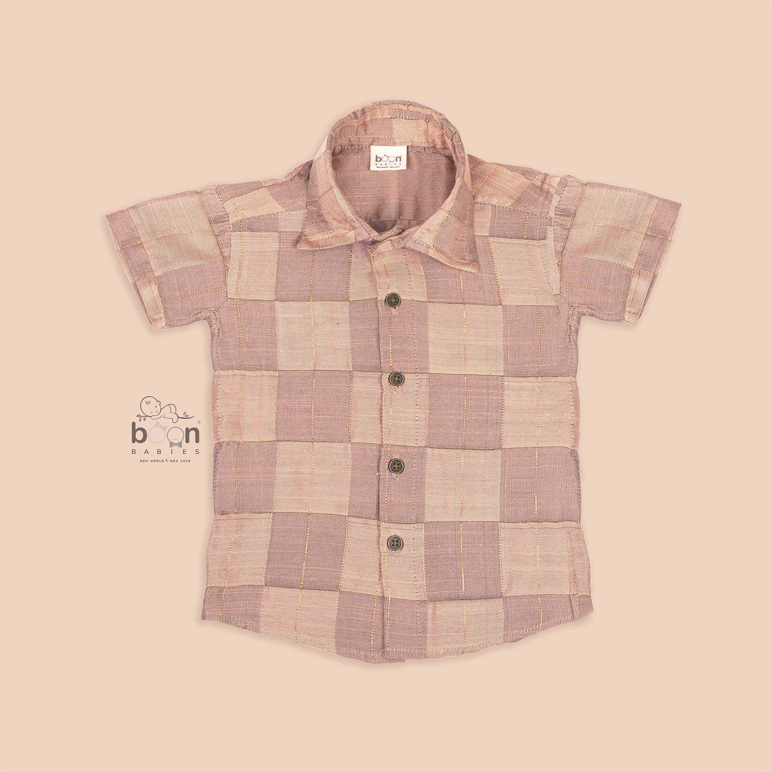 Pastel beige silk shirt with subtle golden checks, folded neatly beside a white veshti – premium boys’ ethnic shirt from Boon Babies, Coimbatore.