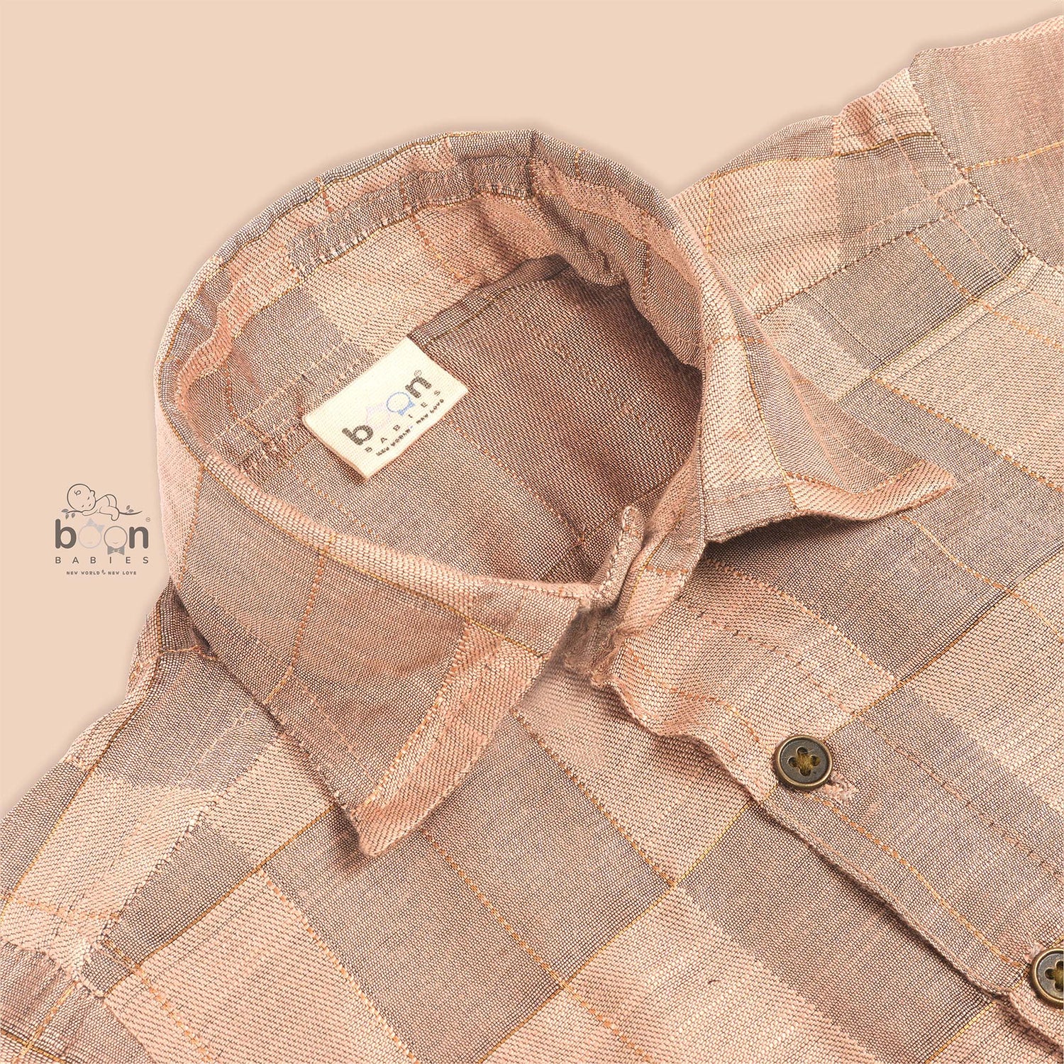 Pastel beige silk shirt with subtle golden checks, folded neatly beside a white veshti – premium boys’ ethnic shirt from Boon Babies, Coimbatore.