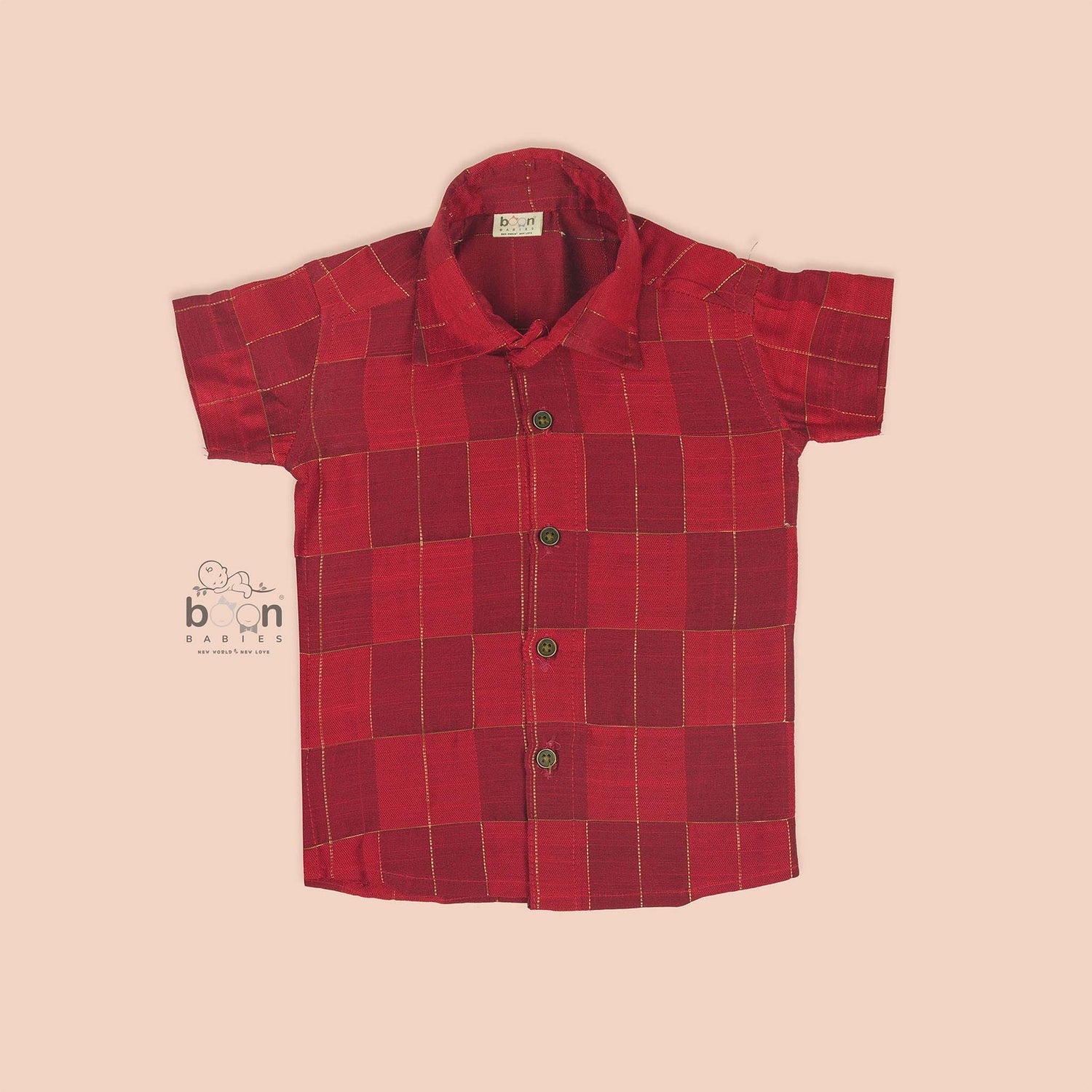Rich red silk shirt with golden check pattern, folded neatly beside a white veshti – premium festive shirt for boys from Boon Babies, Coimbatore.