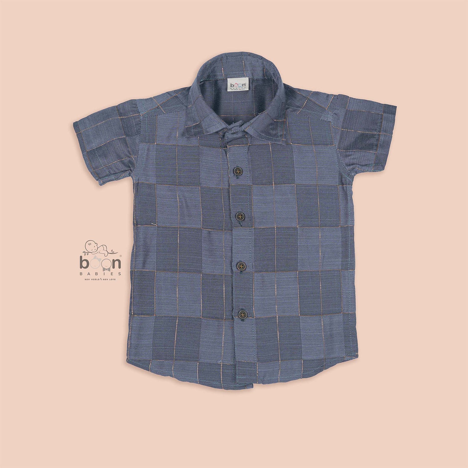 Folded slate grey silk shirt with subtle gold check design placed next to a traditional white veshti – boys’ festive ethnicwear by Boon Babies, Coimbatore.