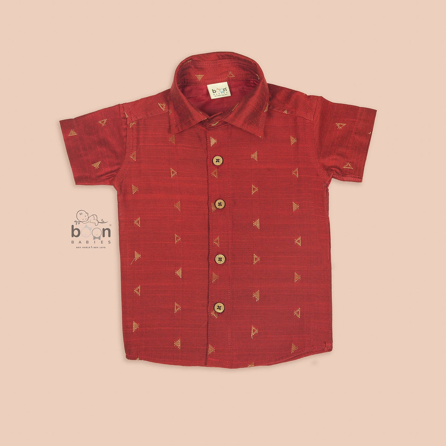 Red silk shirt for boys with gold triangle woven motifs, shown with white pattu dhoti – traditional outfit by Boon Babies.
