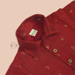 Red silk shirt for boys with gold triangle woven motifs, shown with white pattu dhoti – traditional outfit by Boon Babies.
