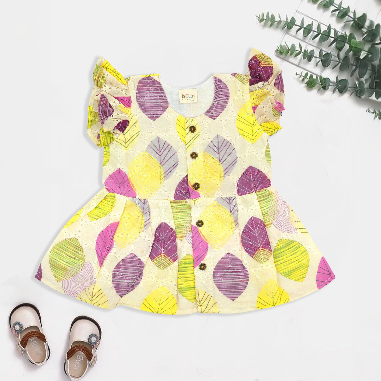 Baby girls hakoba frill frock with leaf print in yellow, purple & pink (NB–24M). Soft cotton, frill sleeves & button-down style – comfy & stylish.