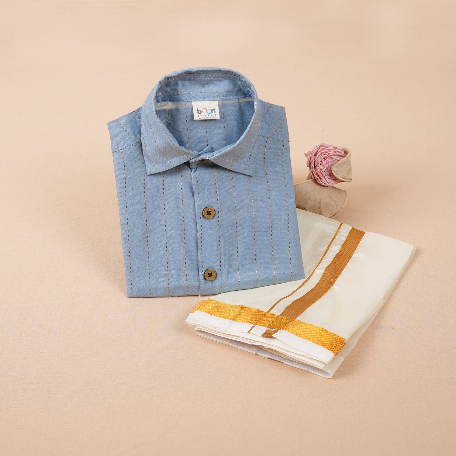 Sky blue silk shirt with gold thread stripes, paired with a white pattu dhoti – traditional festive wear set for boys by Boon Babies (ages 12M to 5Y).
