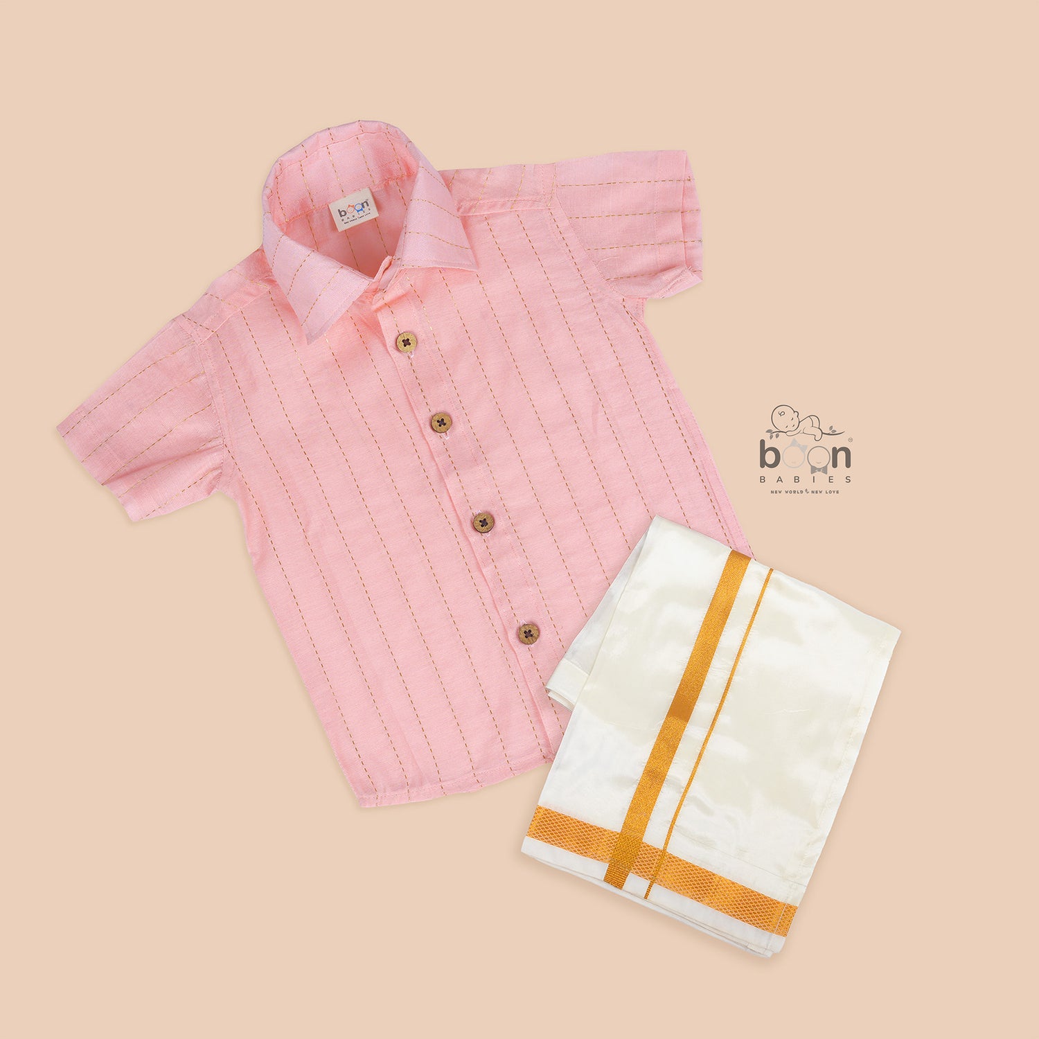 Peach pink silk shirt with gold lines and white pattu dhoti with golden border – boys’ traditional wear set from Boon Babies.
