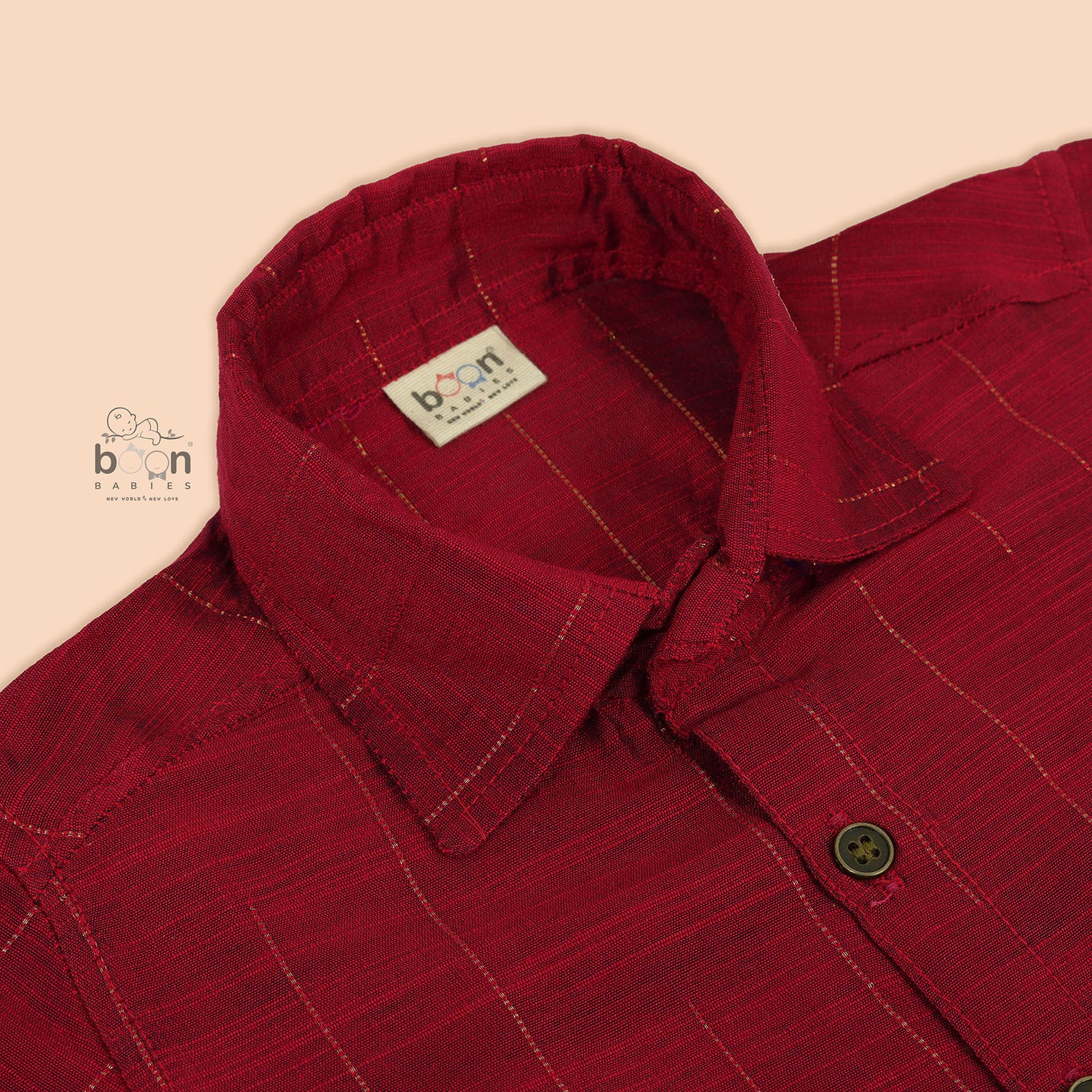 Maroon silk shirt with vertical golden lines, folded next to a traditional white veshti – boys' festive ethnic shirt by Boon Babies, Coimbatore.