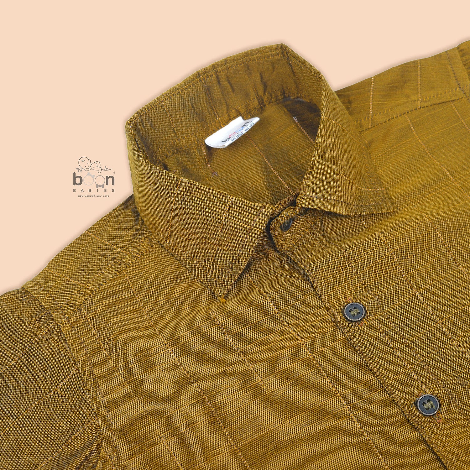 Mustard gold silk shirt with subtle golden stripes, folded beside a traditional white veshti – Boon Babies’ festive ethnicwear for boys in Coimbatore.