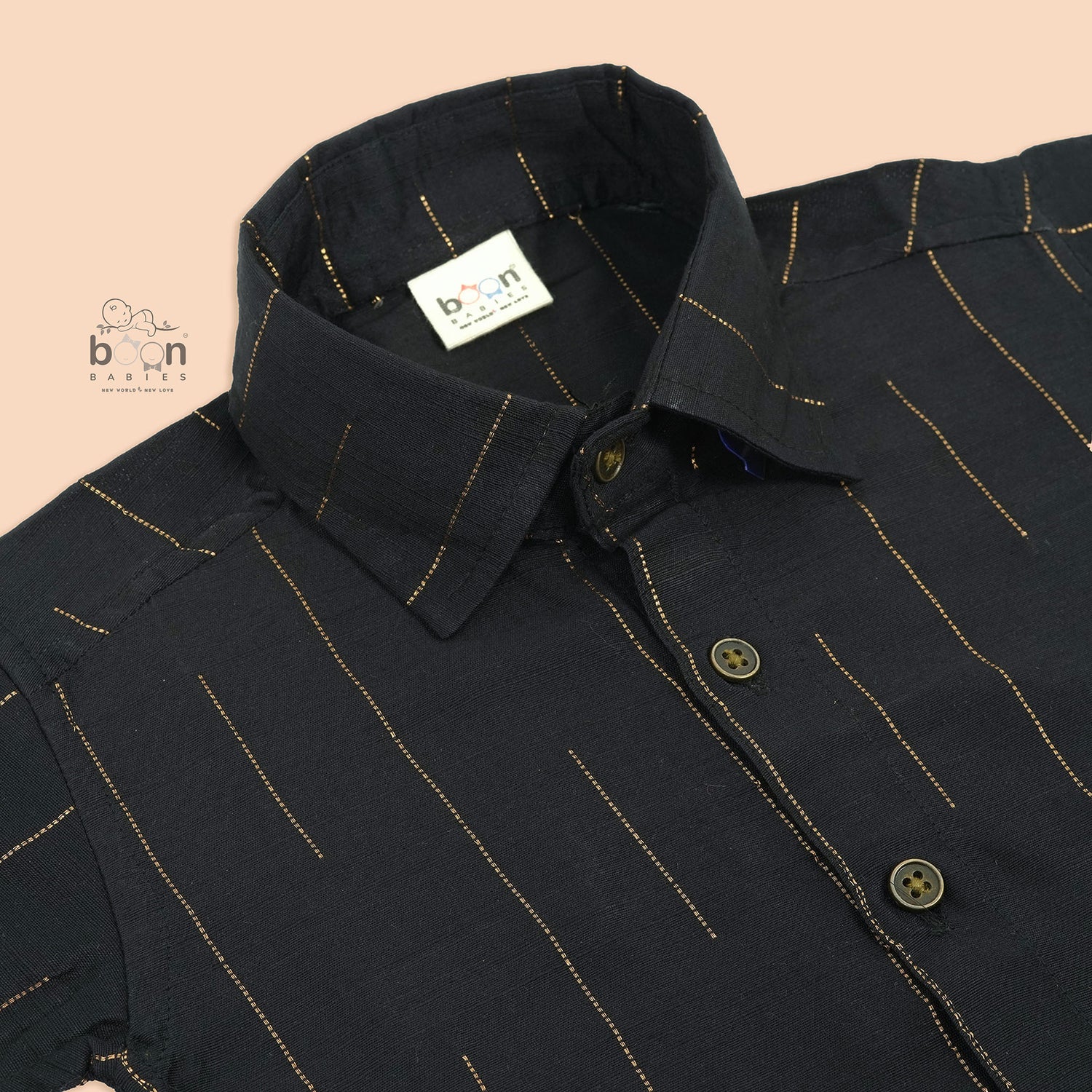 Folded black silk shirt with golden vertical lines, paired with traditional white veshti – premium ethnicwear for boys by Boon Babies, Coimbatore.