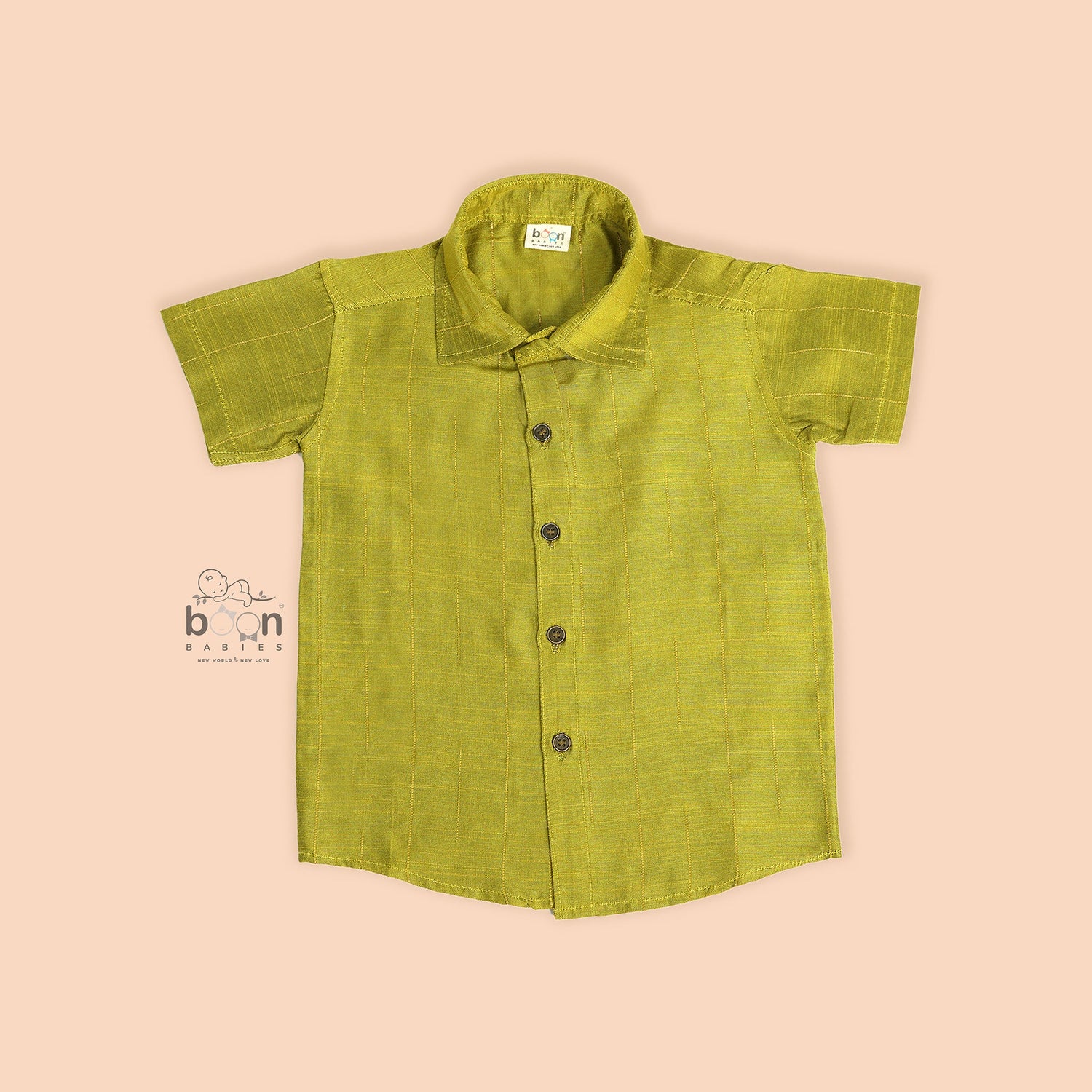 Boys lime green silk shirt with gold detailing, folded beside a white dhoti – festive kidswear set by Boon Babies.