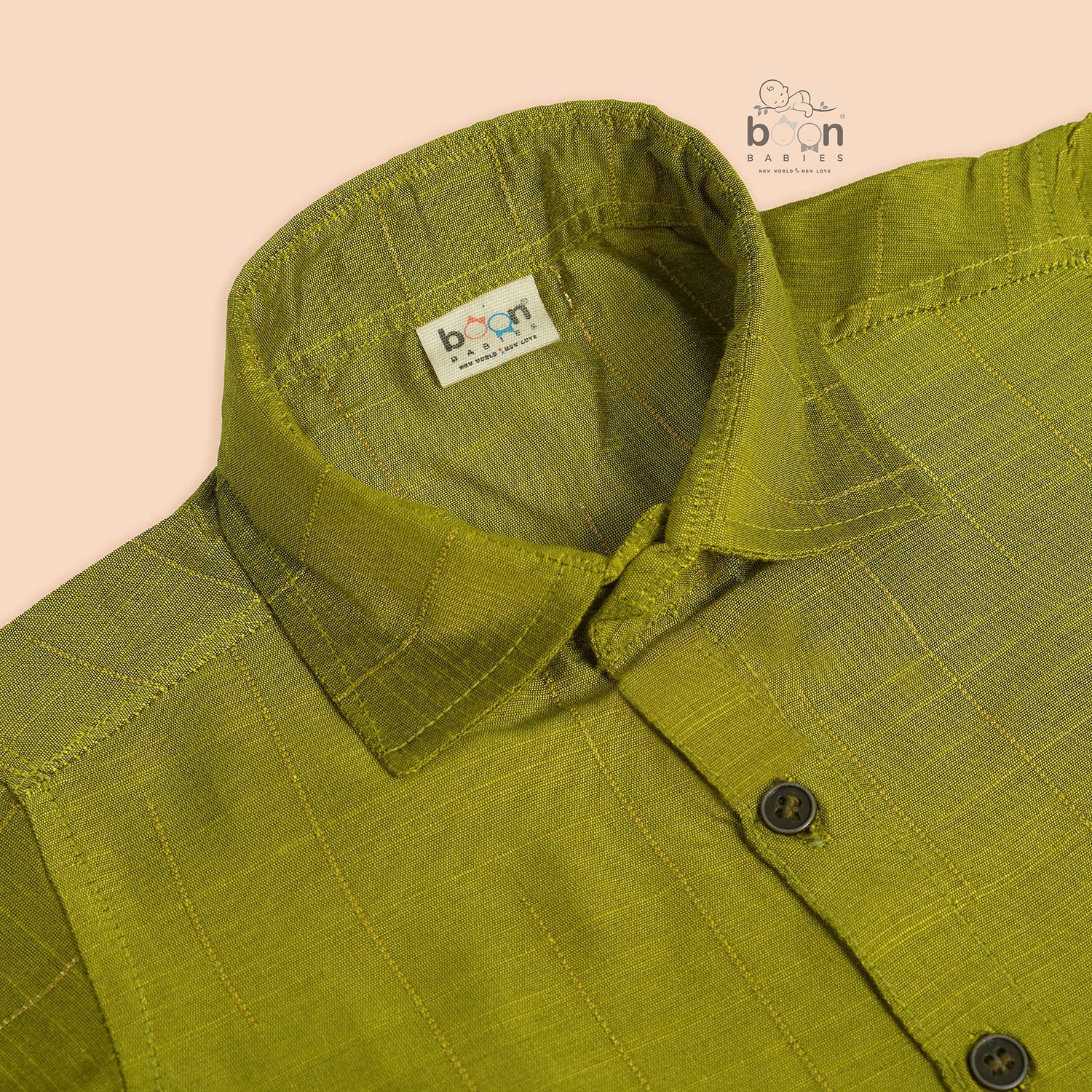 Boys lime green silk shirt with gold detailing, folded beside a white dhoti – festive kidswear set by Boon Babies.