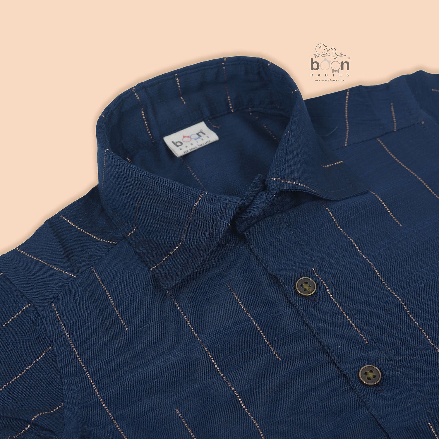 Boys navy blue silk shirt with subtle gold stripes, folded beside a white and gold pattu dhoti – Boon Babies festive wear.