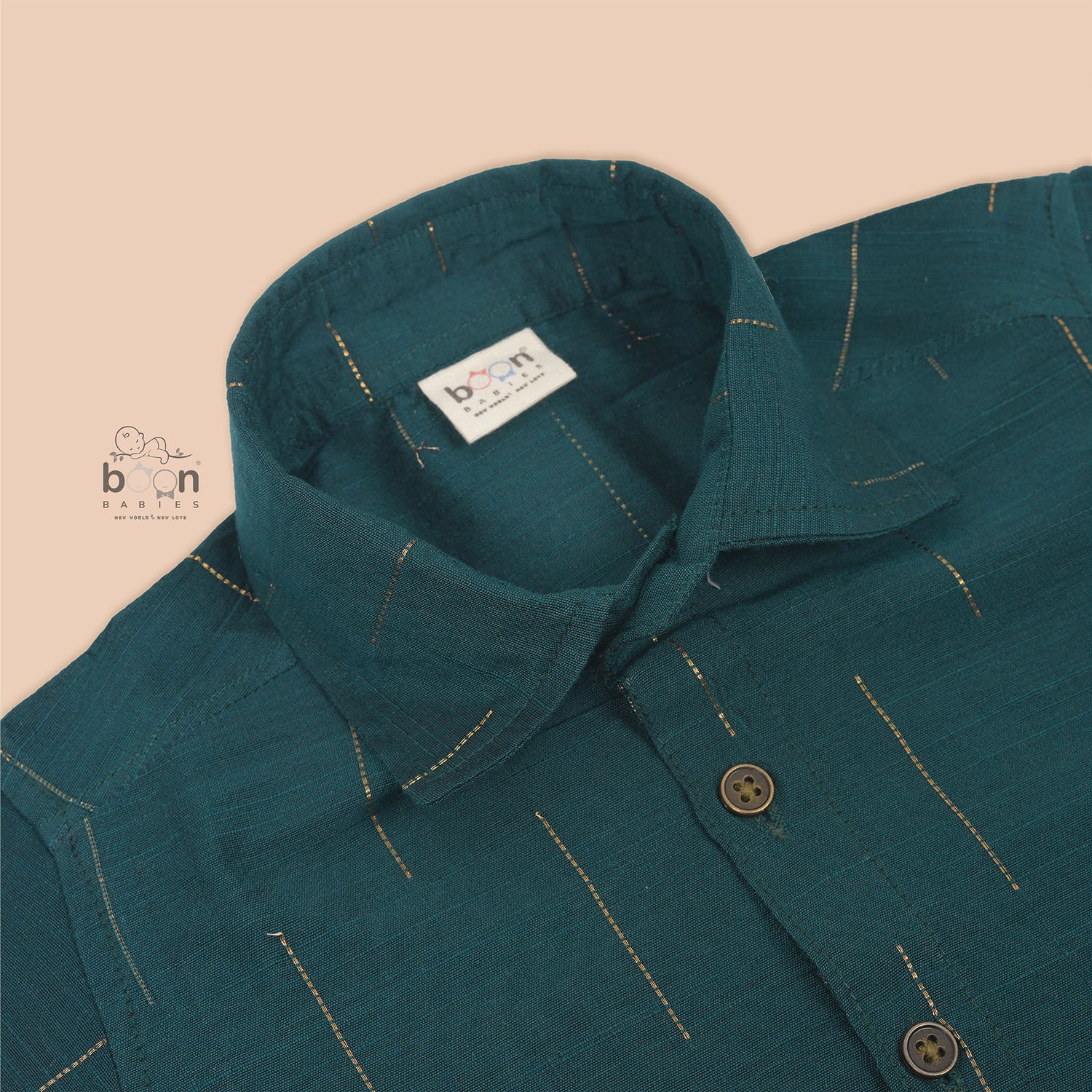 Teal green silk shirt for boys with gold vertical detailing, neatly paired with traditional white pattu dhoti – festive wear set by Boon Babies.
